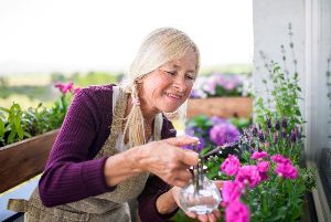 Woman Gardening on Balcony — Nicholasville, KY — Stewart Air Conditioning & Heating