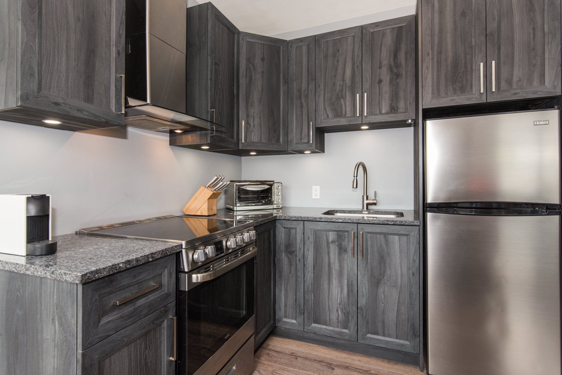 Une cuisine avec des appareils électroménagers en acier inoxydable et des armoires grises