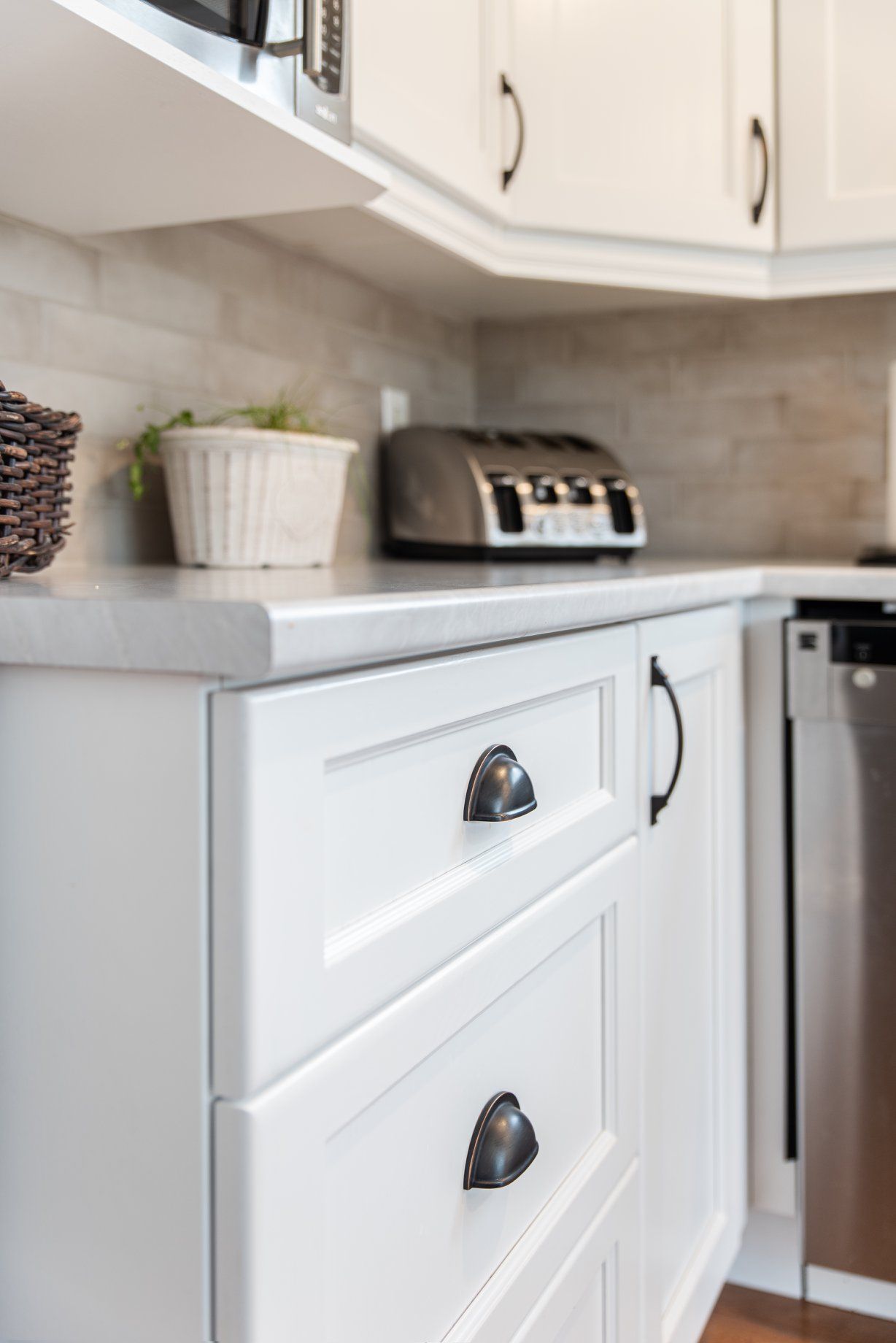 Une cuisine avec des armoires blanches et des appareils électroménagers en acier inoxydable.