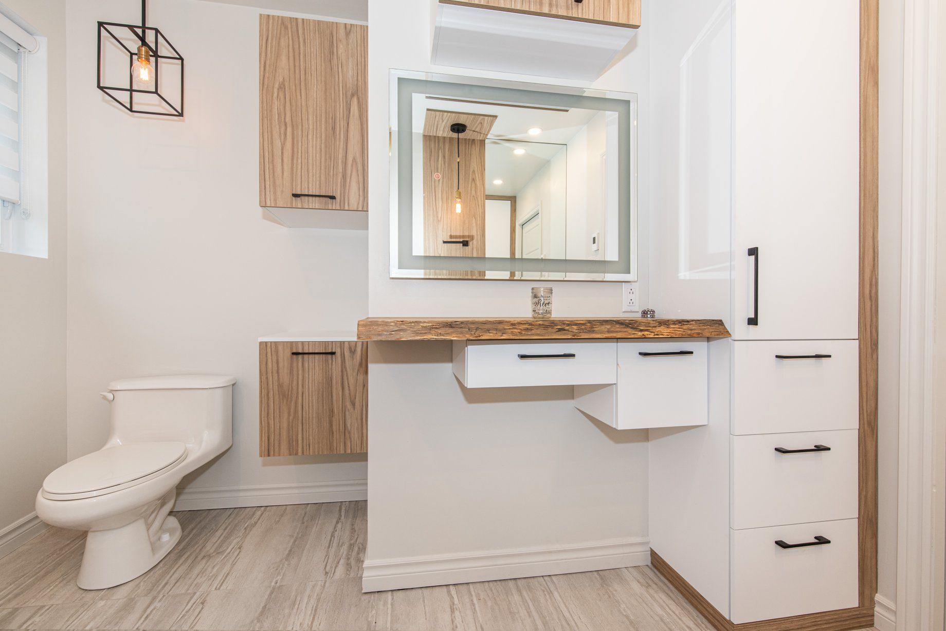 Une salle de bain avec WC, lavabo et miroir.