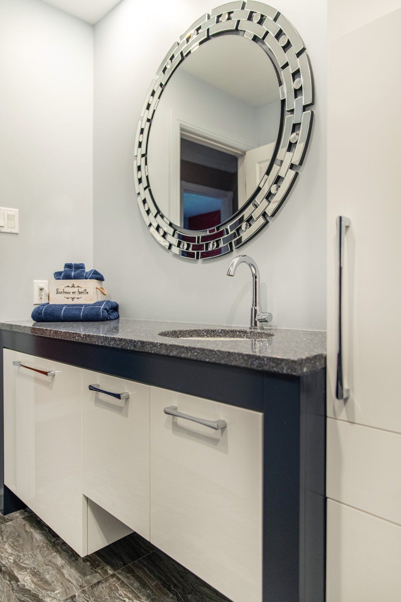 Une salle de bain avec lavabo, miroir et armoires.