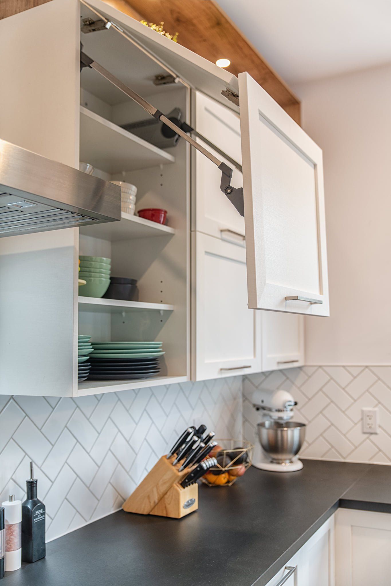 Une cuisine avec des armoires blanches et un comptoir noir.