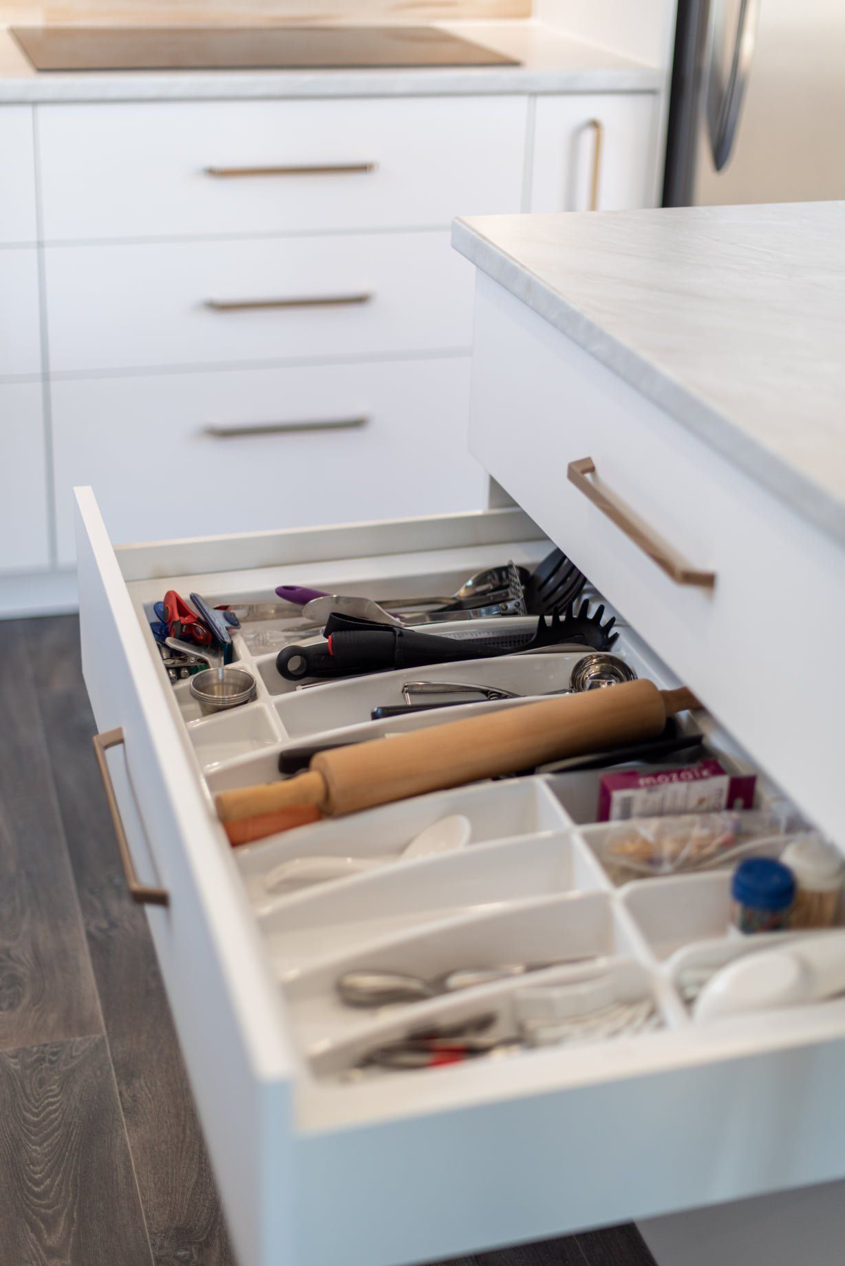 Un tiroir de cuisine rempli d'ustensiles et d'un rouleau à pâtisserie.
