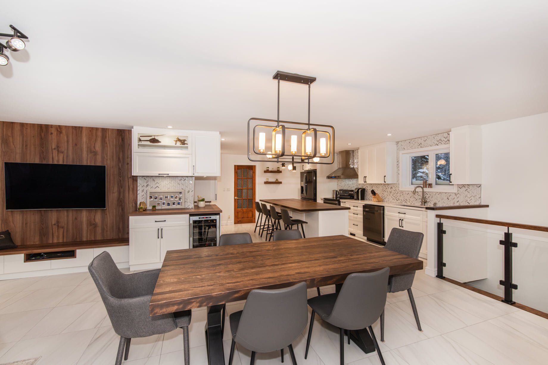 Une salle à manger avec une table et des chaises en bois et une télévision à écran plat.