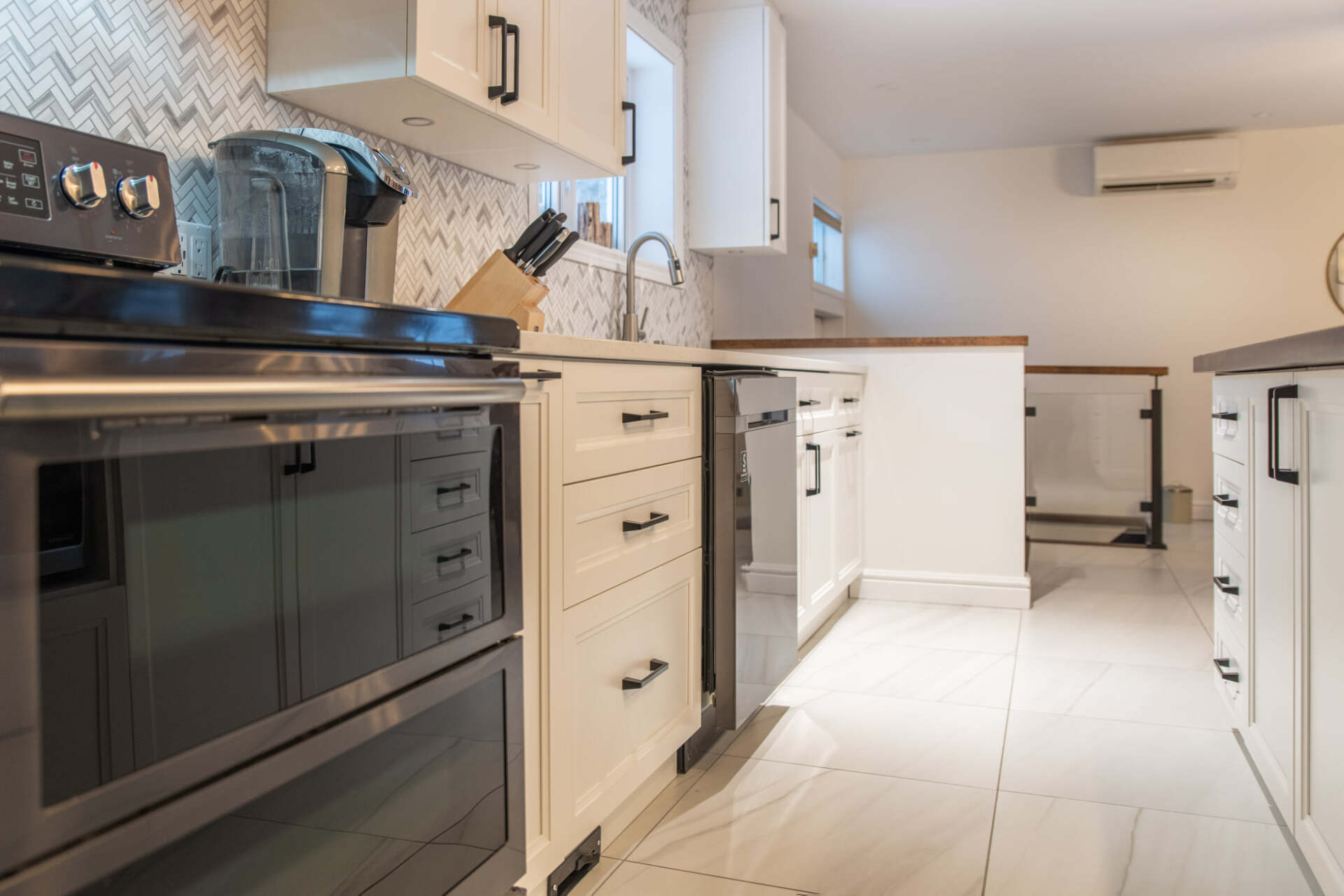 Une cuisine avec des appareils électroménagers en acier inoxydable et des armoires blanches.