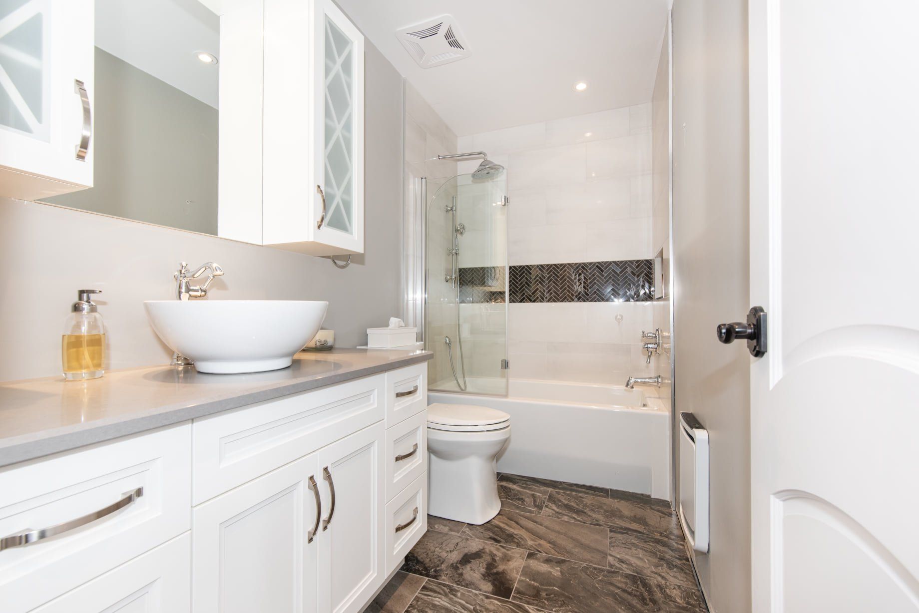 Une salle de bain avec lavabo, WC, baignoire et miroir.