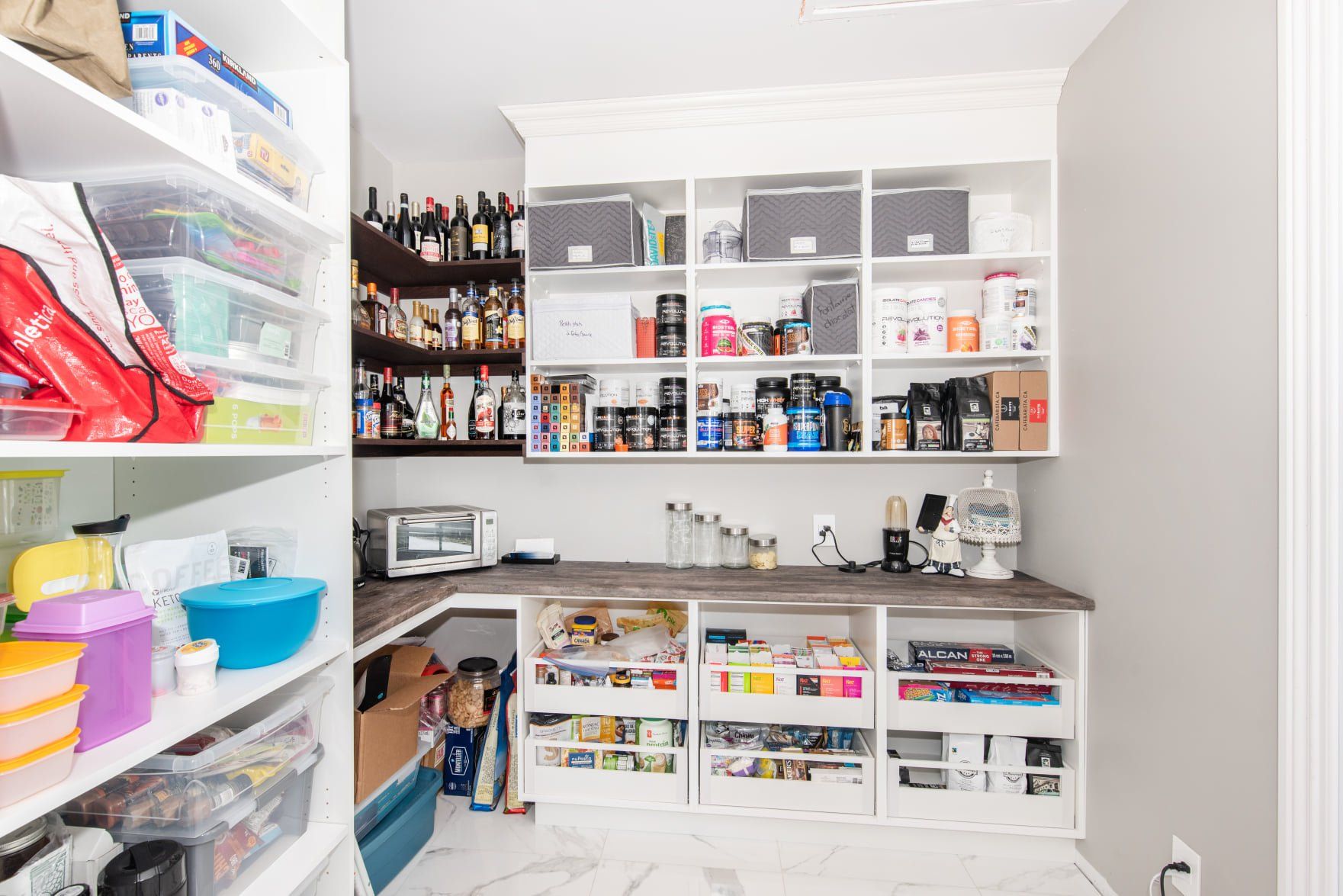 Un garde-manger rempli de nombreuses étagères et boîtes.