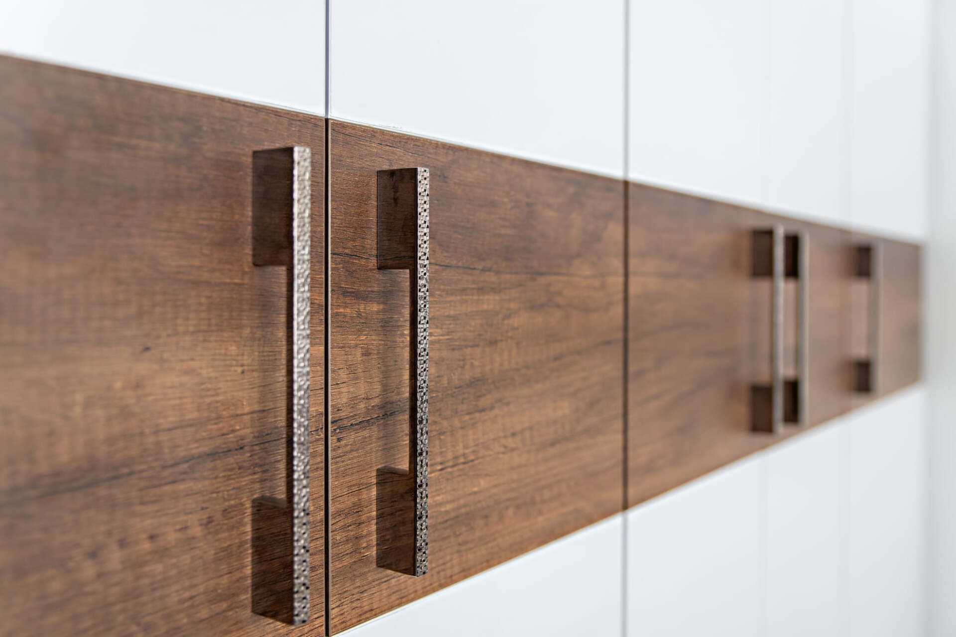 Un gros plan d'une armoire en bois avec des poignées en métal.