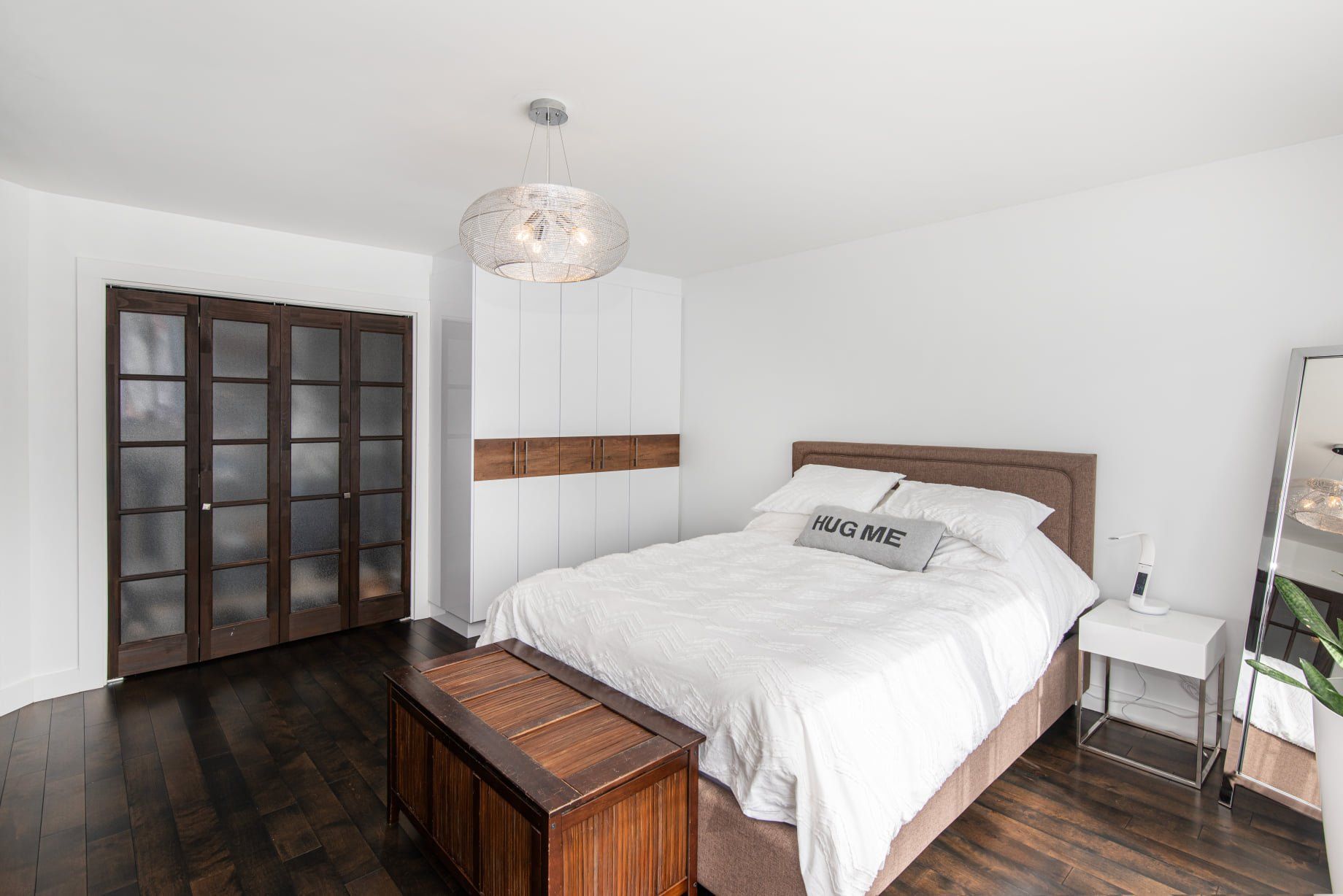 Il y a un grand lit au milieu de la pièce.