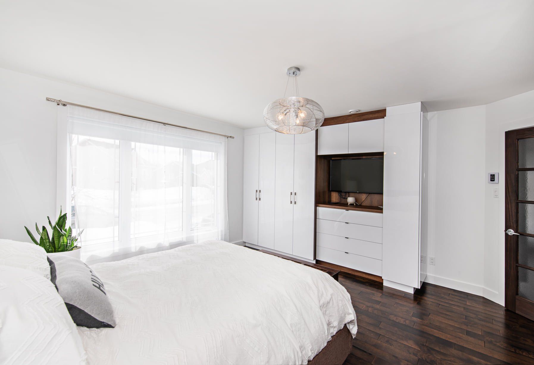 Une chambre avec un grand lit, une commode et une télévision.