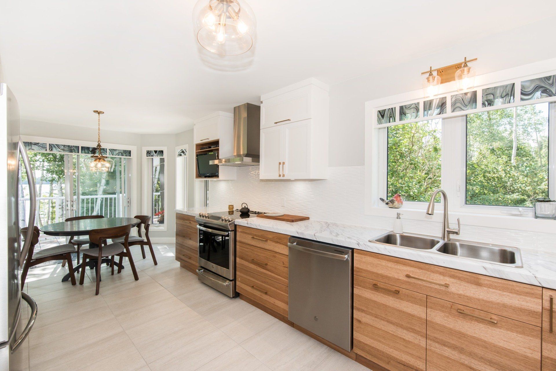 Une cuisine avec des armoires en bois, des électroménagers en acier inoxydable, un évier et une table.