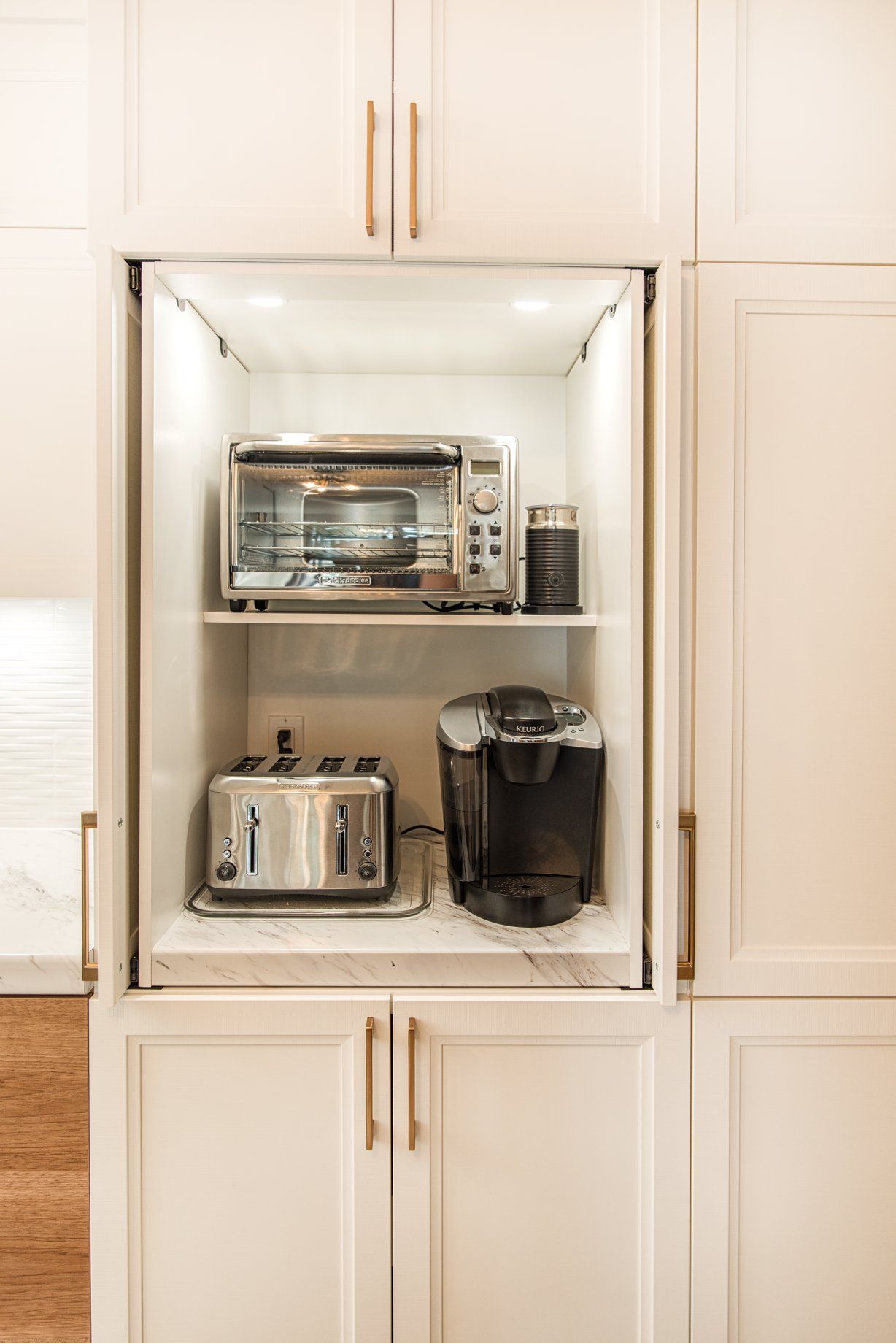 Un meuble de cuisine avec un four grille-pain, une cafetière et un micro-ondes.