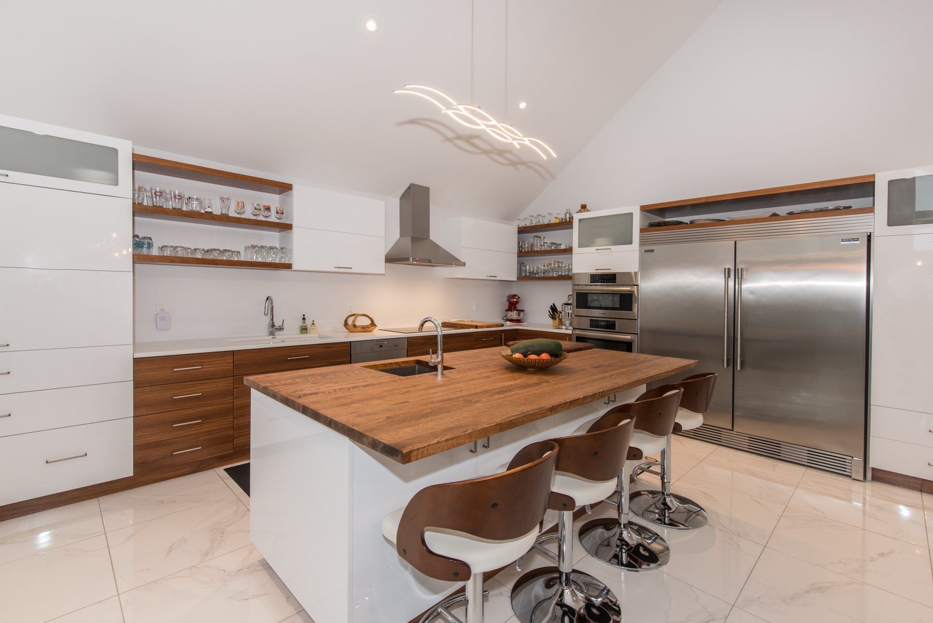 Une cuisine avec des appareils électroménagers en acier inoxydable, des armoires en bois et un grand îlot.