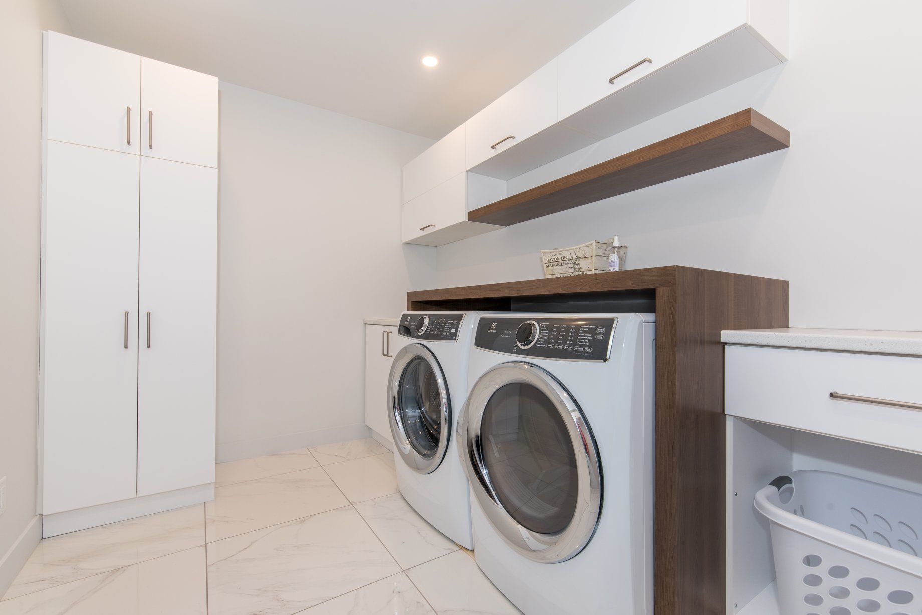 Une buanderie avec laveuse et sécheuse et un panier.