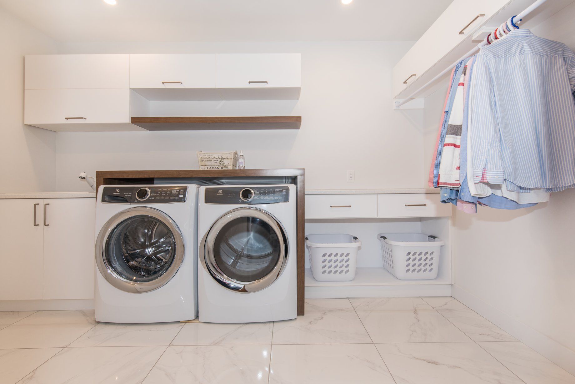 Une buanderie avec laveuse, sécheuse et paniers.