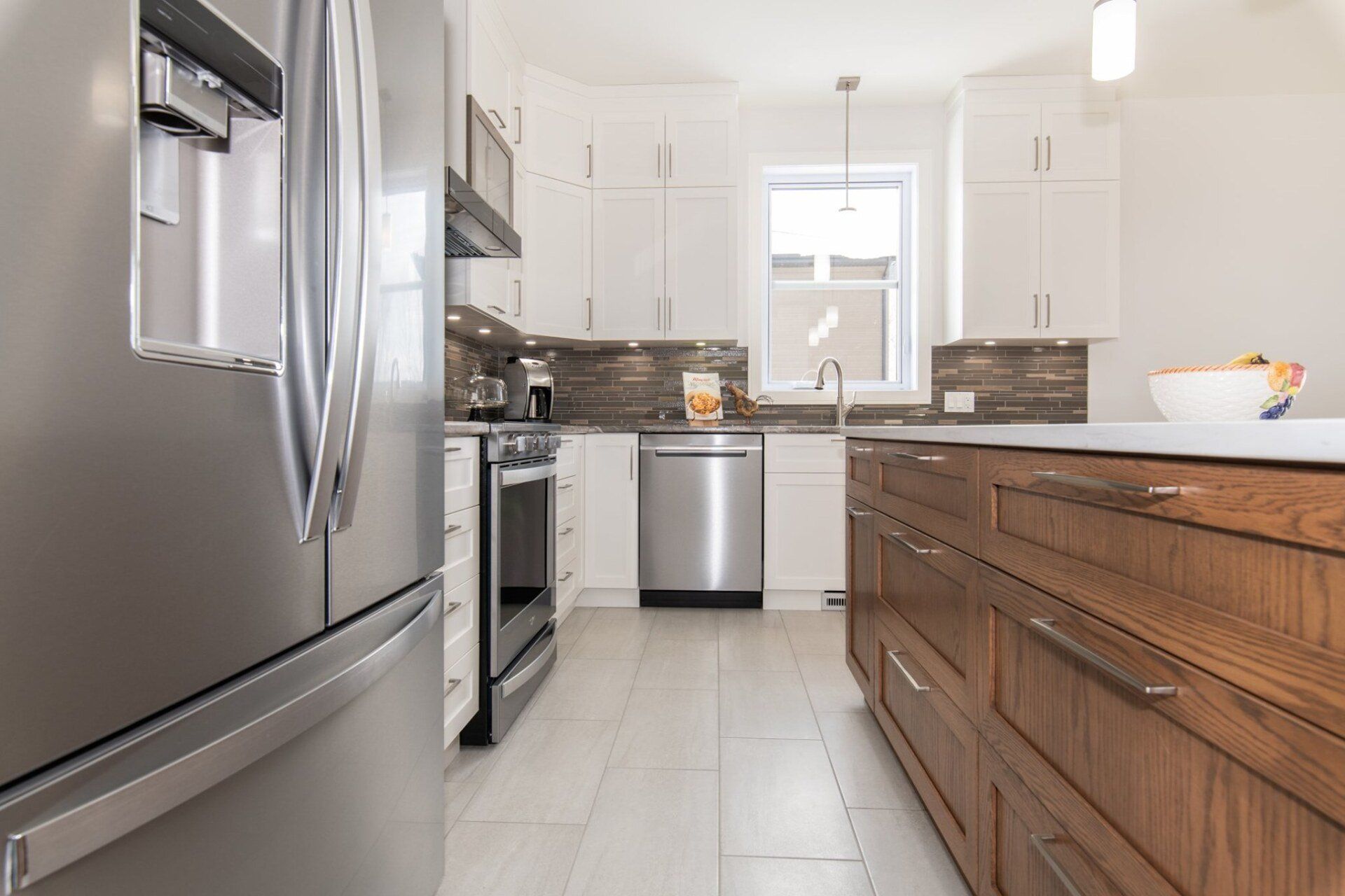 Une cuisine avec électroménagers en acier inoxydable et armoires en bois.