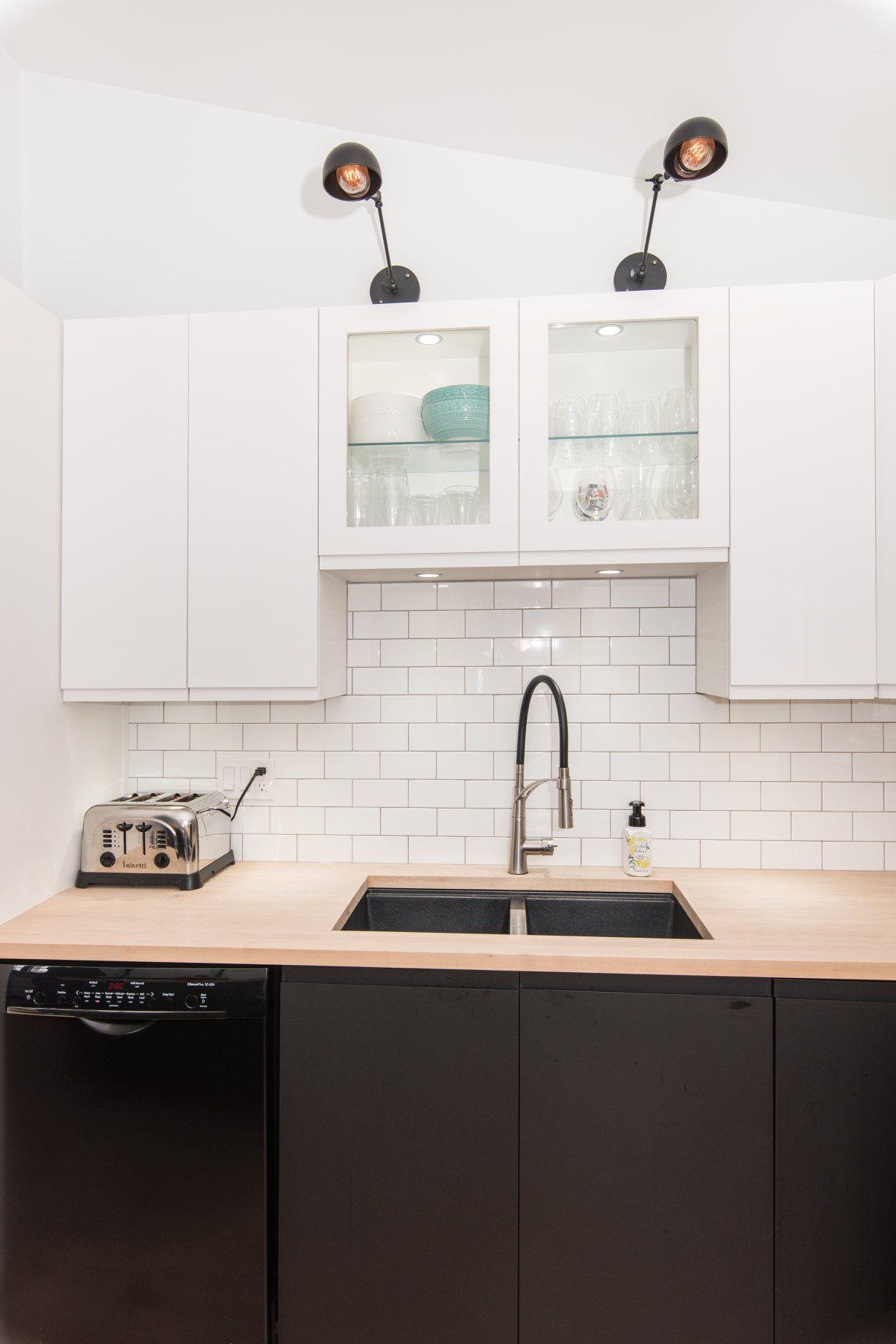 Une cuisine avec un évier, un four grille-pain et un lave-vaisselle.