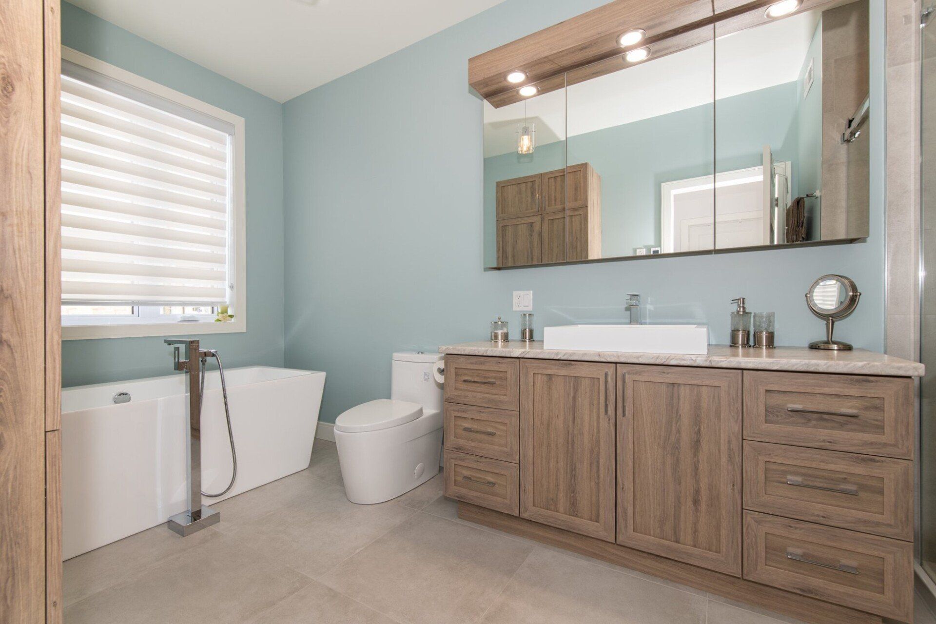 Une salle de bain avec baignoire, WC, lavabo et miroir.