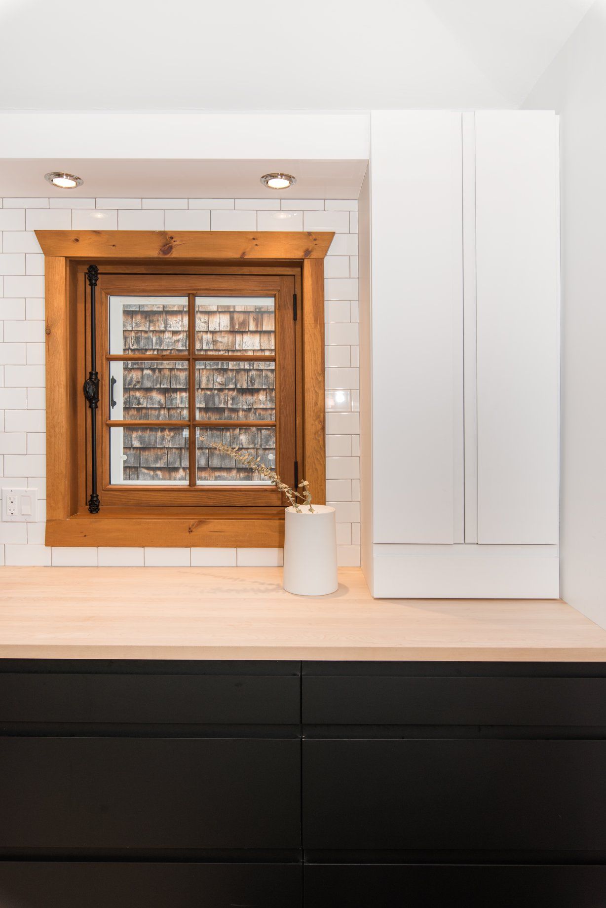 Il y a une fenêtre dans la cuisine avec un cadre en bois.