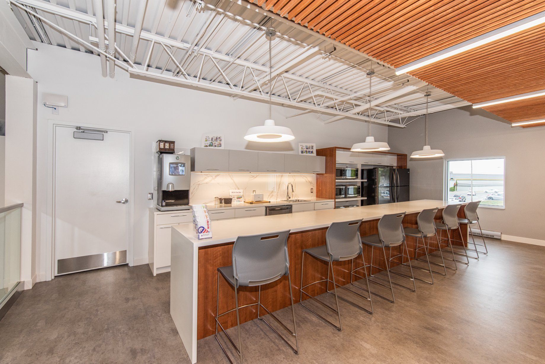 Une cuisine avec un long comptoir et des chaises dans une grande pièce.