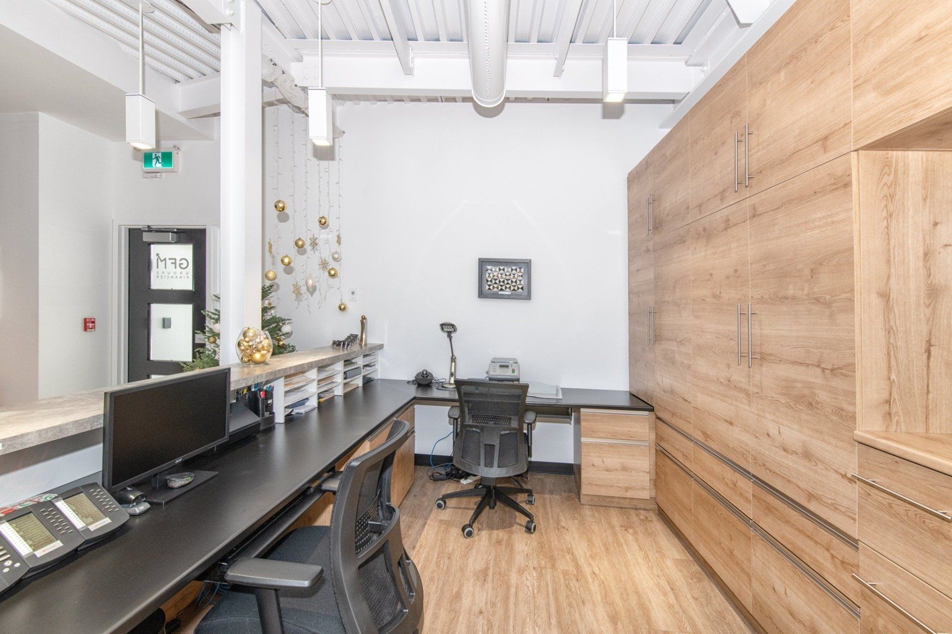 Une pièce avec un bureau, des chaises et un ordinateur dessus.