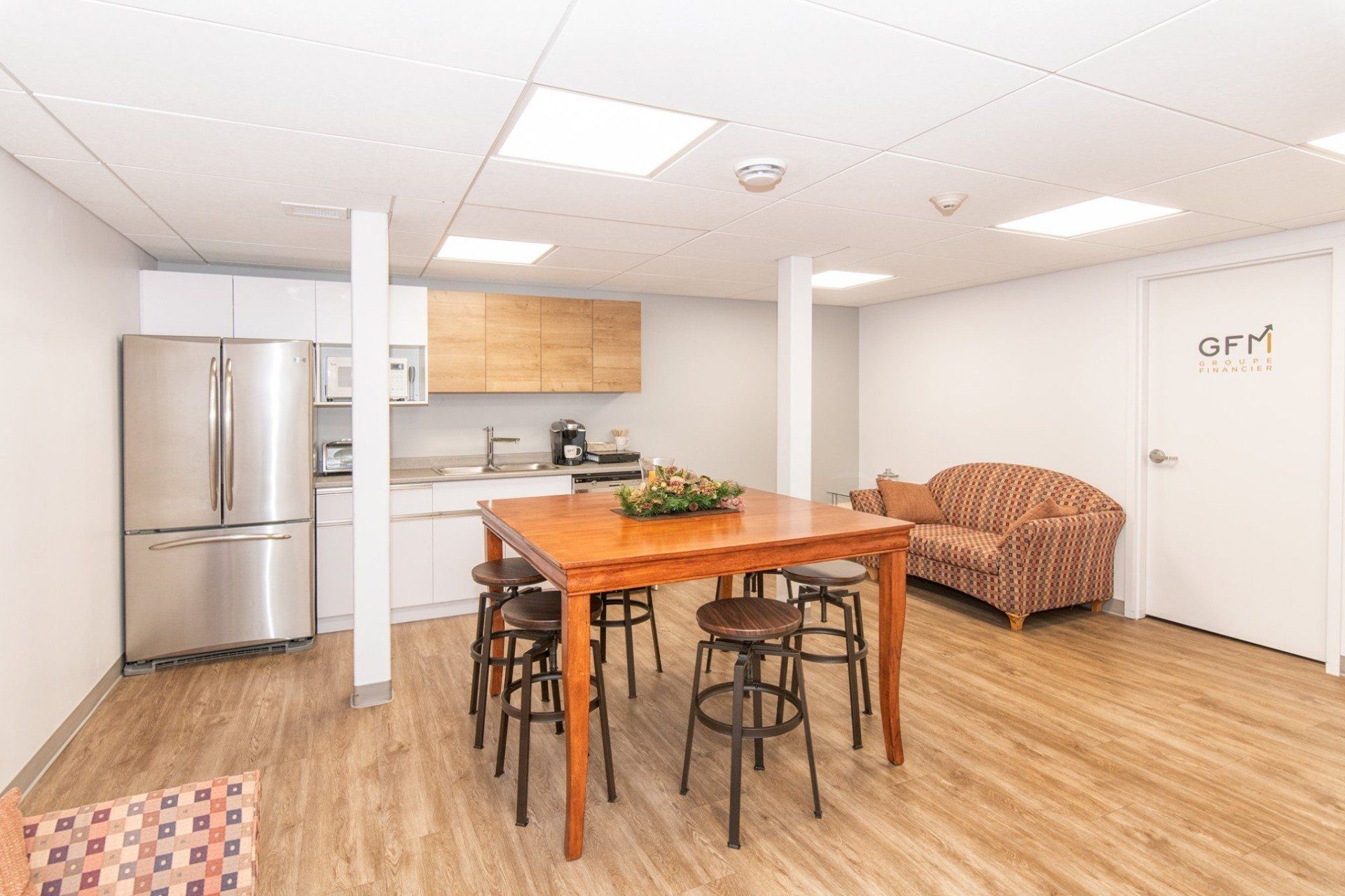 Une cuisine avec une table et des tabourets et un canapé.