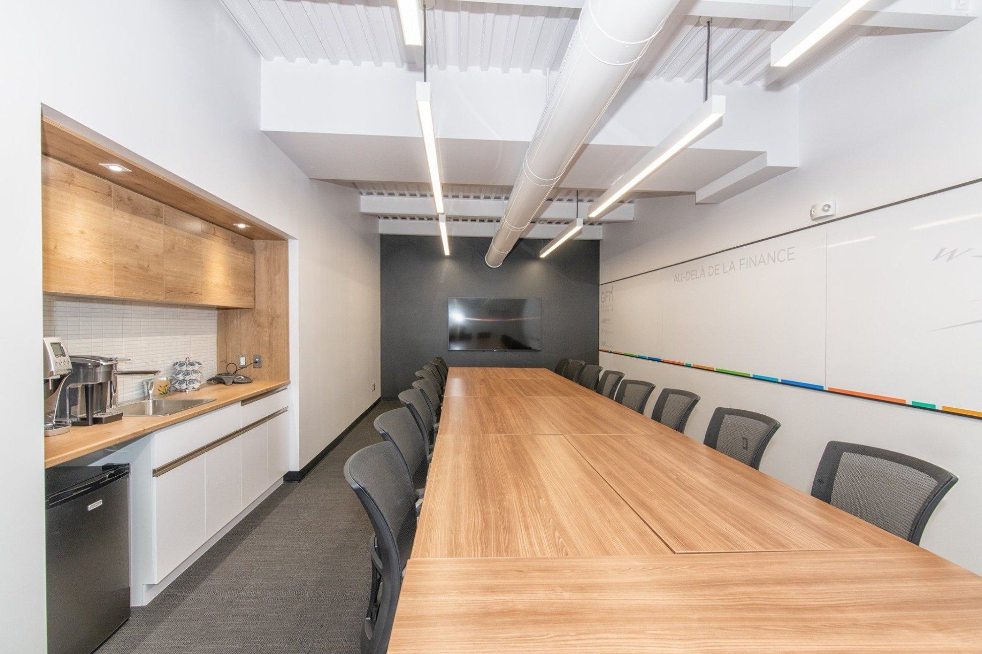 Une salle de conférence avec une longue table en bois et des chaises.