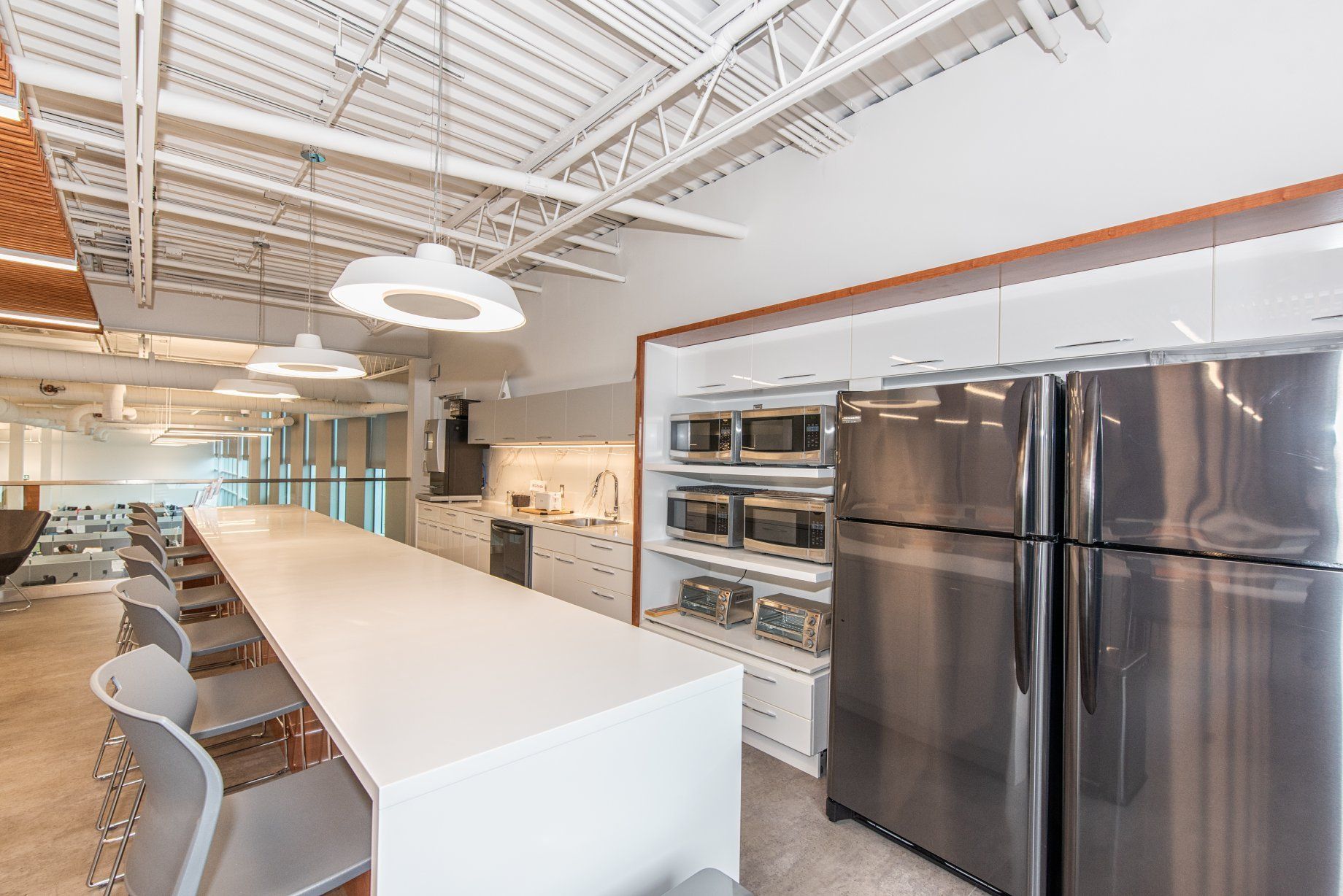 Une cuisine avec des appareils en acier inoxydable et une longue table.