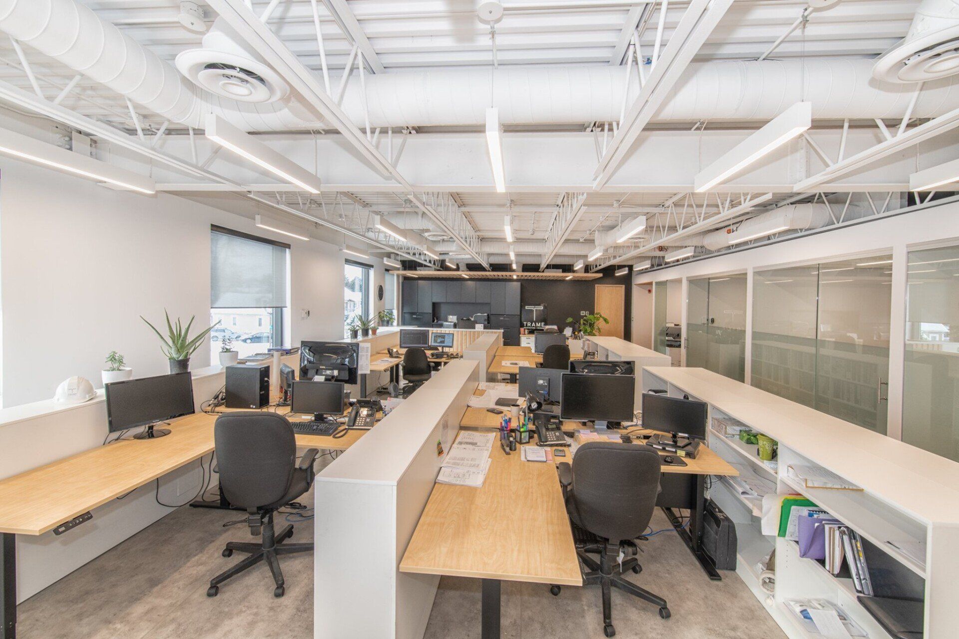 Un grand bureau avec beaucoup de bureaux, de chaises et d'ordinateurs.