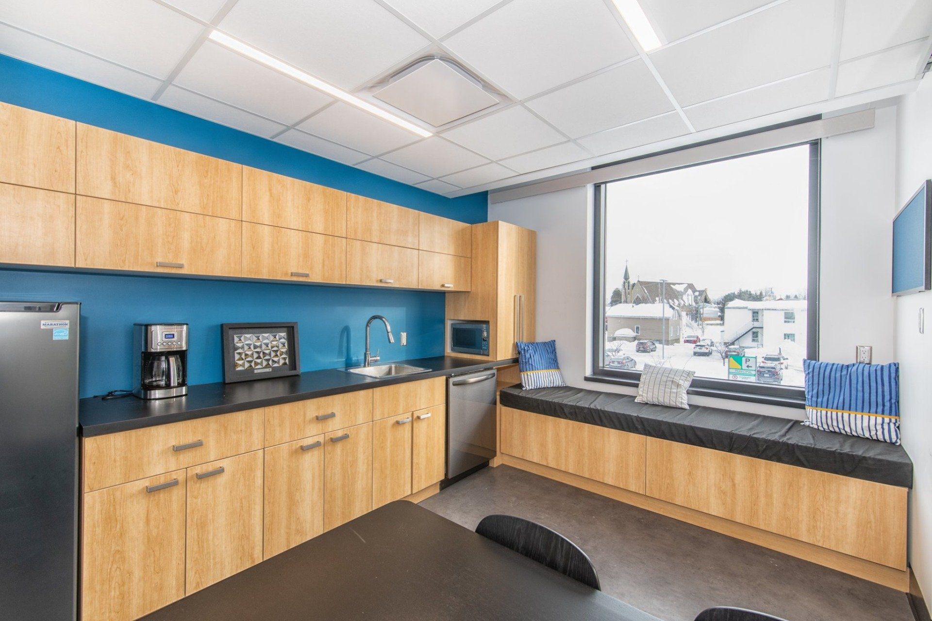 Une cuisine avec des armoires en bois et une grande fenêtre.