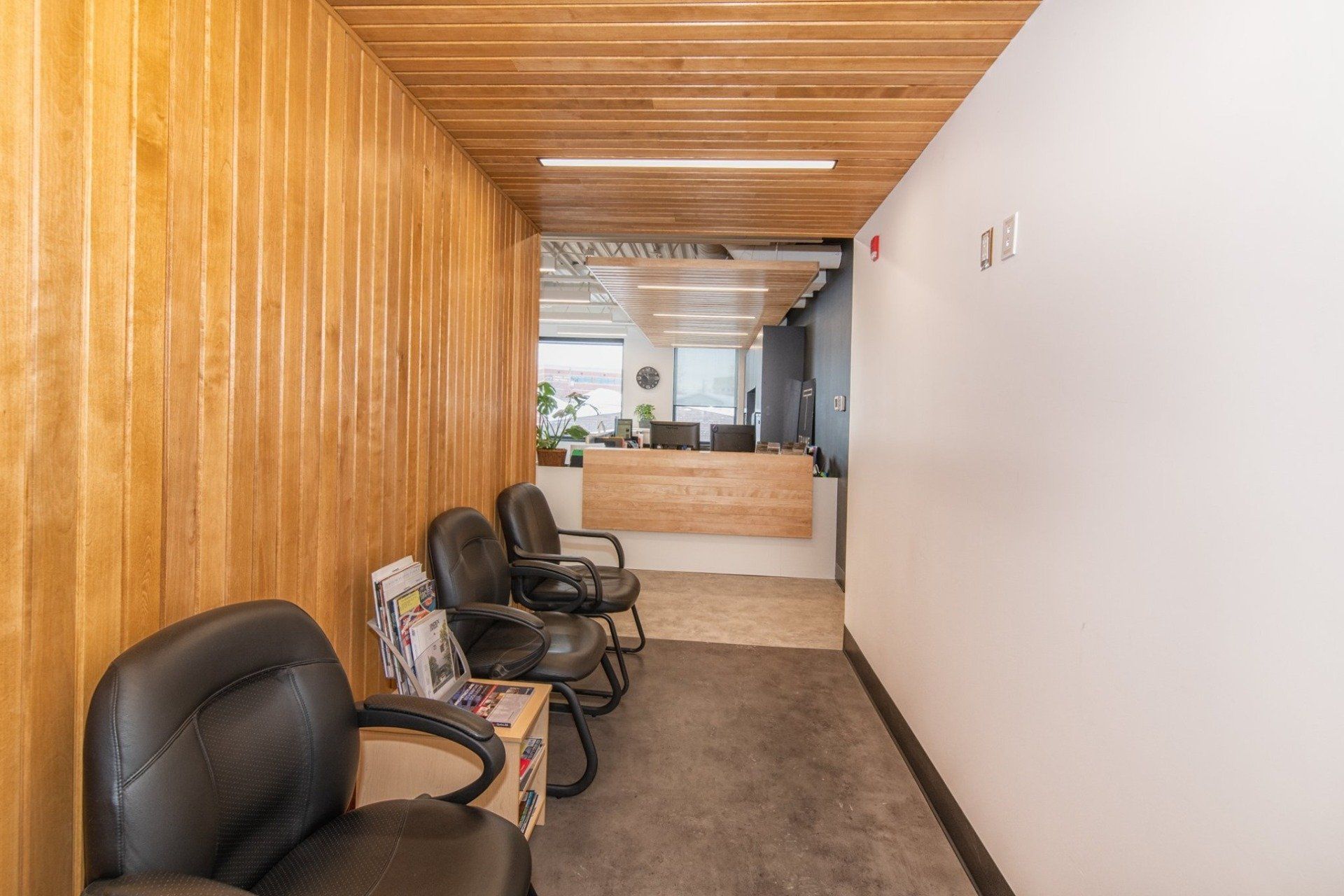 Une salle d'attente avec des chaises et un comptoir dans un bâtiment.