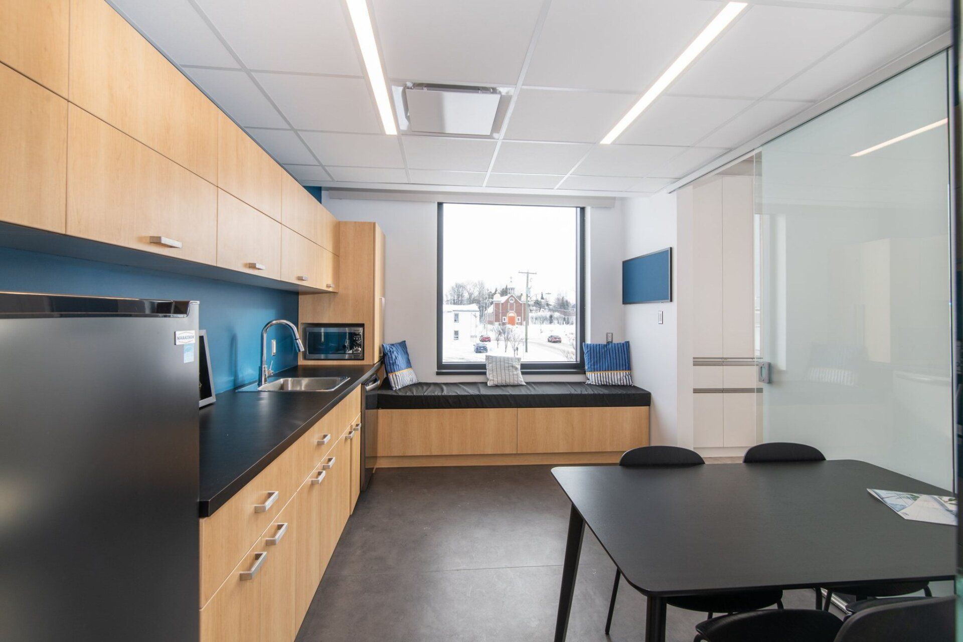 Une cuisine avec une table et des chaises et un réfrigérateur.