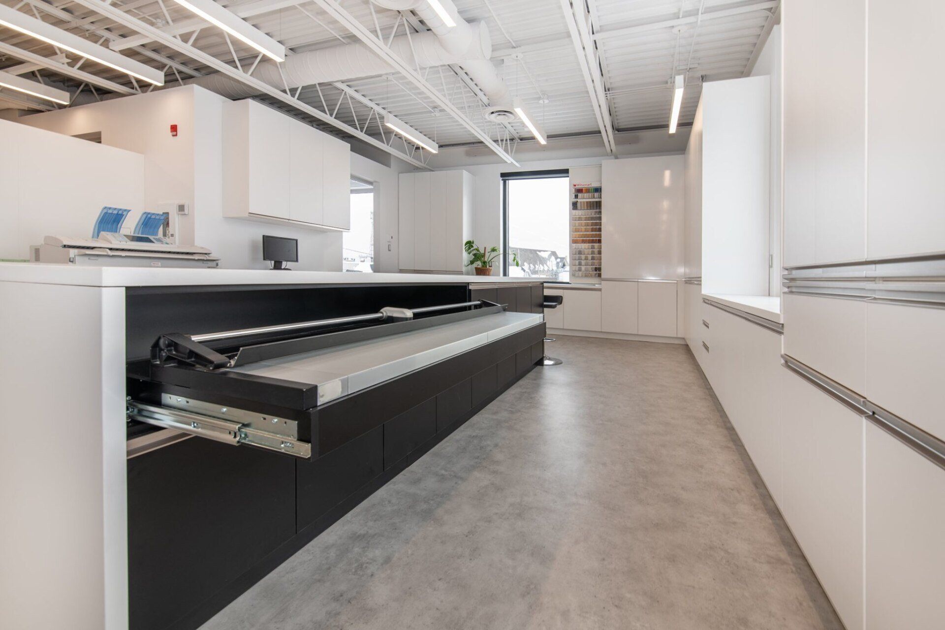 Une cuisine avec un long comptoir et un ordinateur dessus.