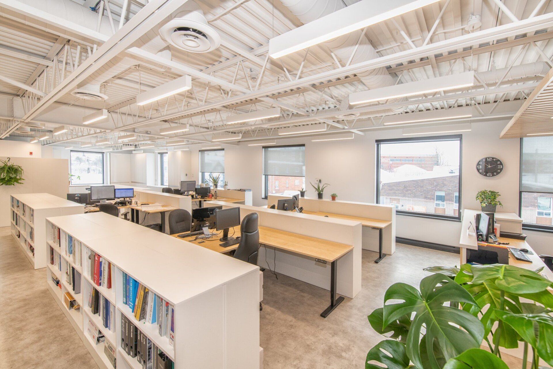 Un grand bureau ouvert avec beaucoup de bureaux et d'étagères de livres.