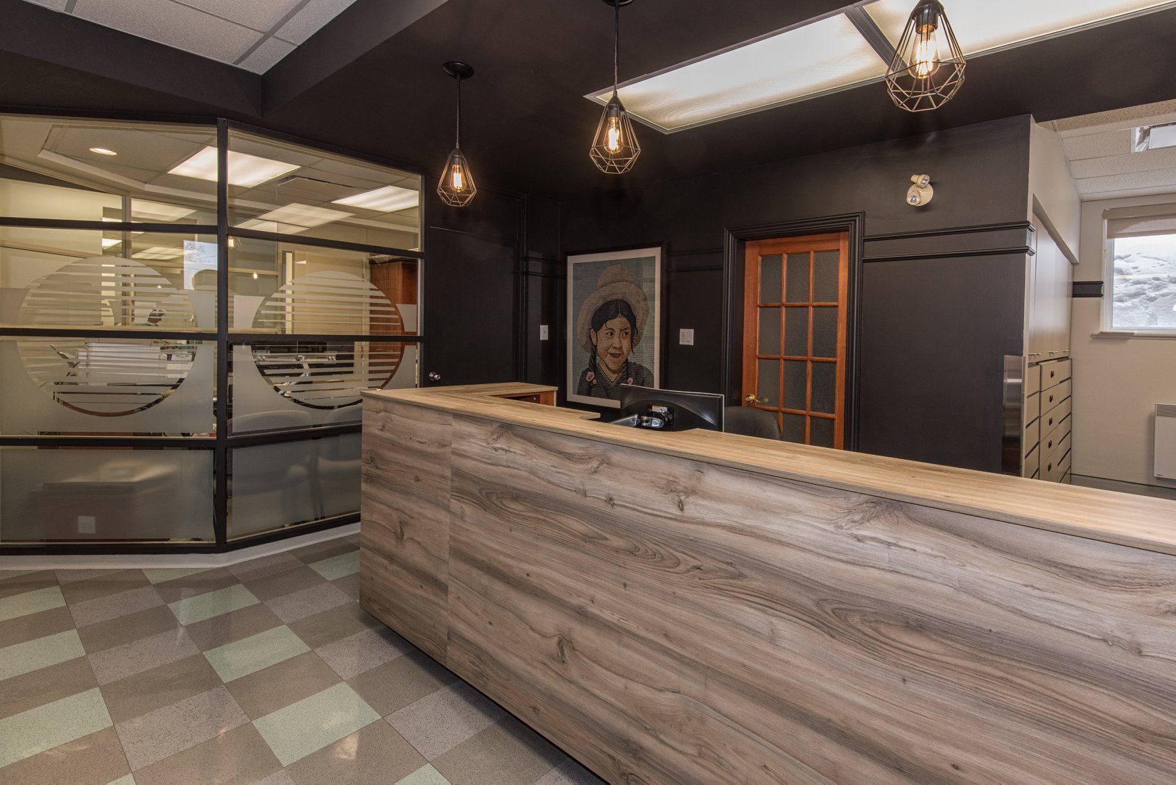 Un espace de réception avec un comptoir en bois et un tableau sur le mur.