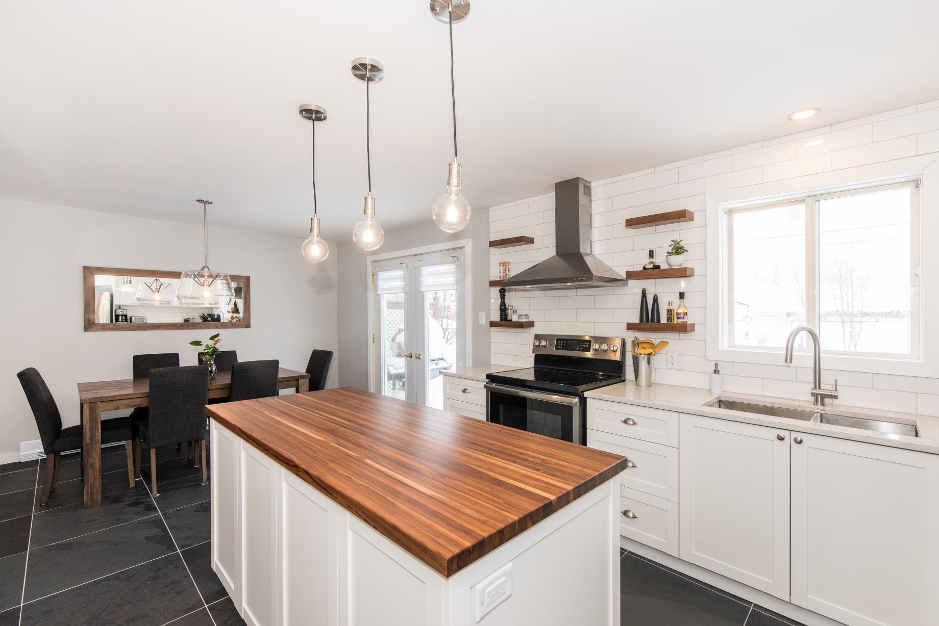 Une cuisine avec des armoires blanches et un comptoir en bois.