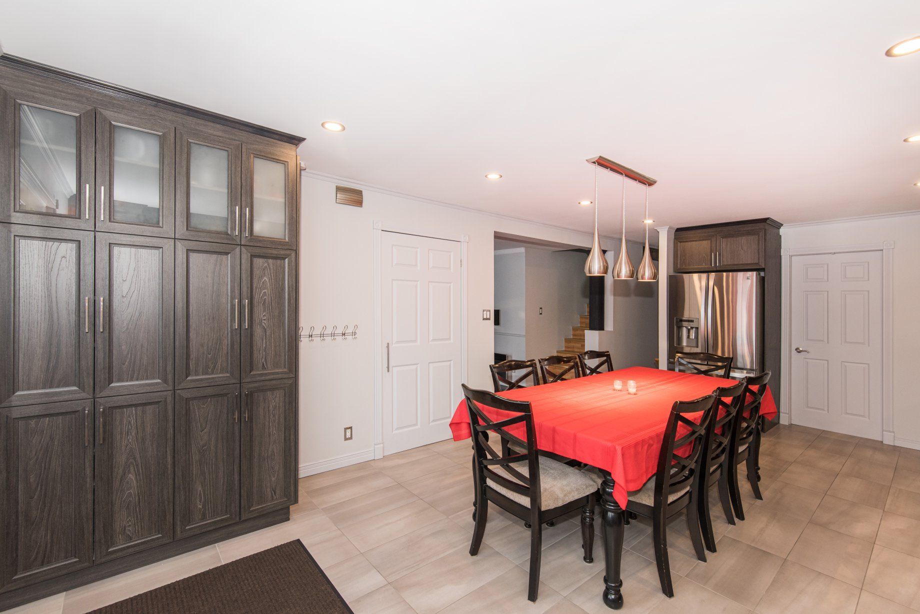 Une salle à manger avec une table et des chaises et une nappe rouge.
