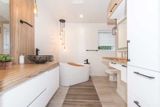 Une salle de bain avec baignoire, lavabo, toilettes et miroir.