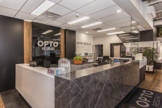 Un comptoir d'accueil dans une salle de sport avec un panneau indiquant opto