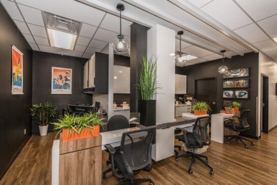 Une pièce avec beaucoup de chaises et de tables et une cuisine en arrière-plan.