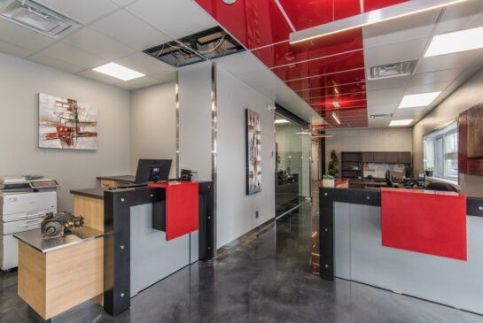 Un grand bureau avec un plafond rouge et deux bureaux rouges