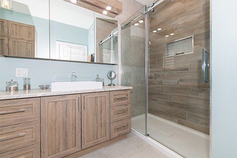Une salle de bain avec lavabo, miroir et douche à l'italienne.