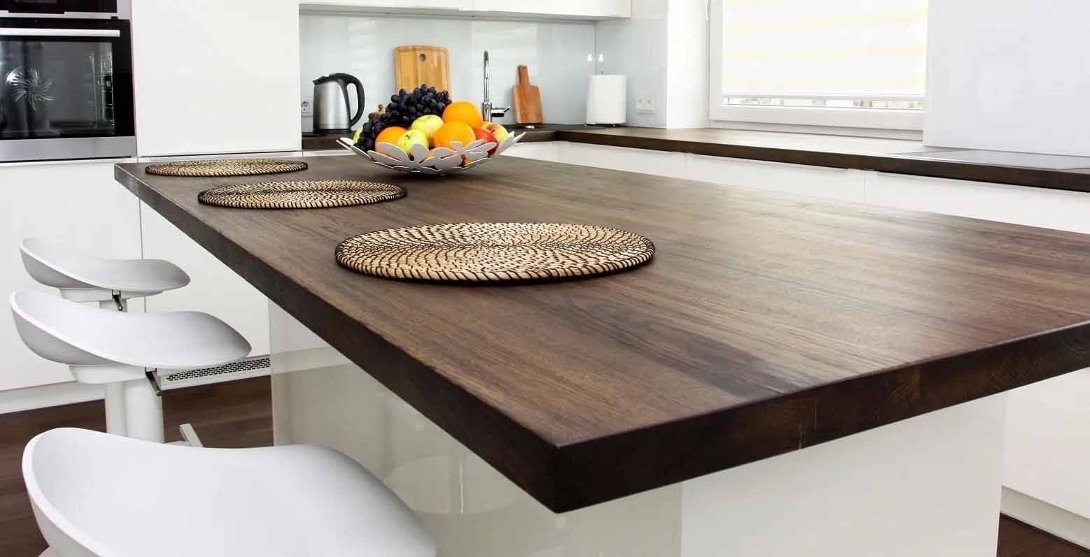 une cuisine avec un comptoir en bois et un bol de fruits dessus.