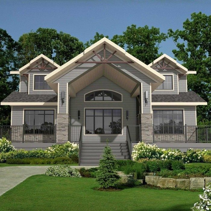 Gray and white house with stone accents, a large front door, and a green lawn.