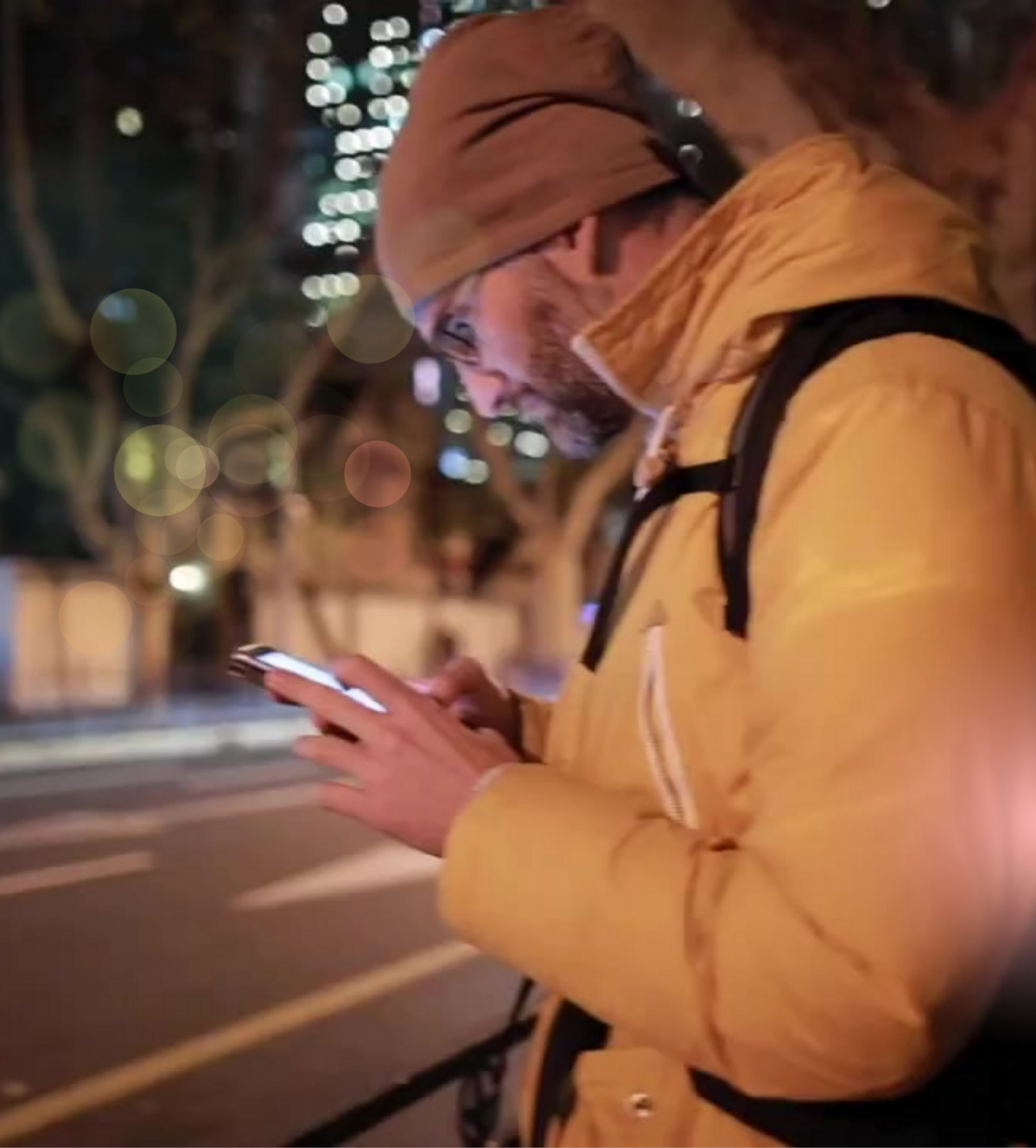 a man in a yellow jacket is looking at his phone