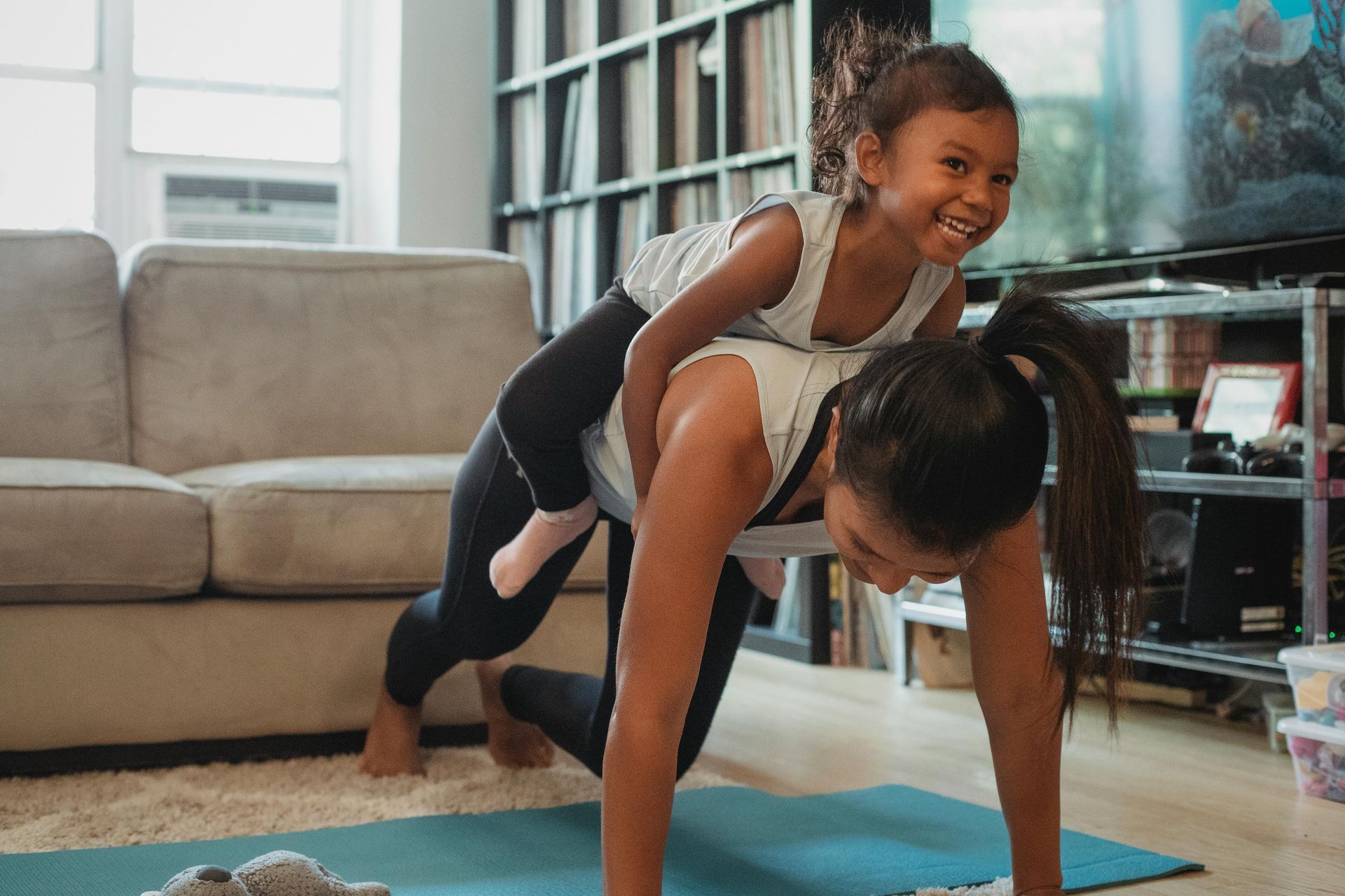 mom and daughter having fun doing core exercise at home with a personal trainer