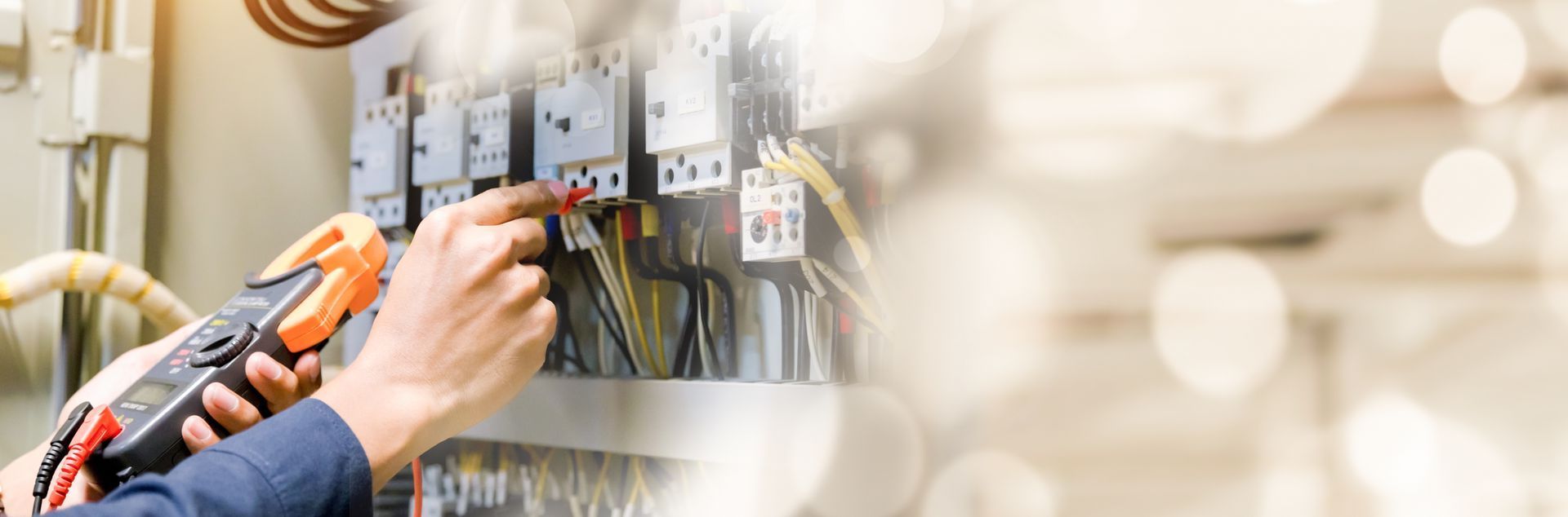A man is working on an electrical panel with a pair of pliers.