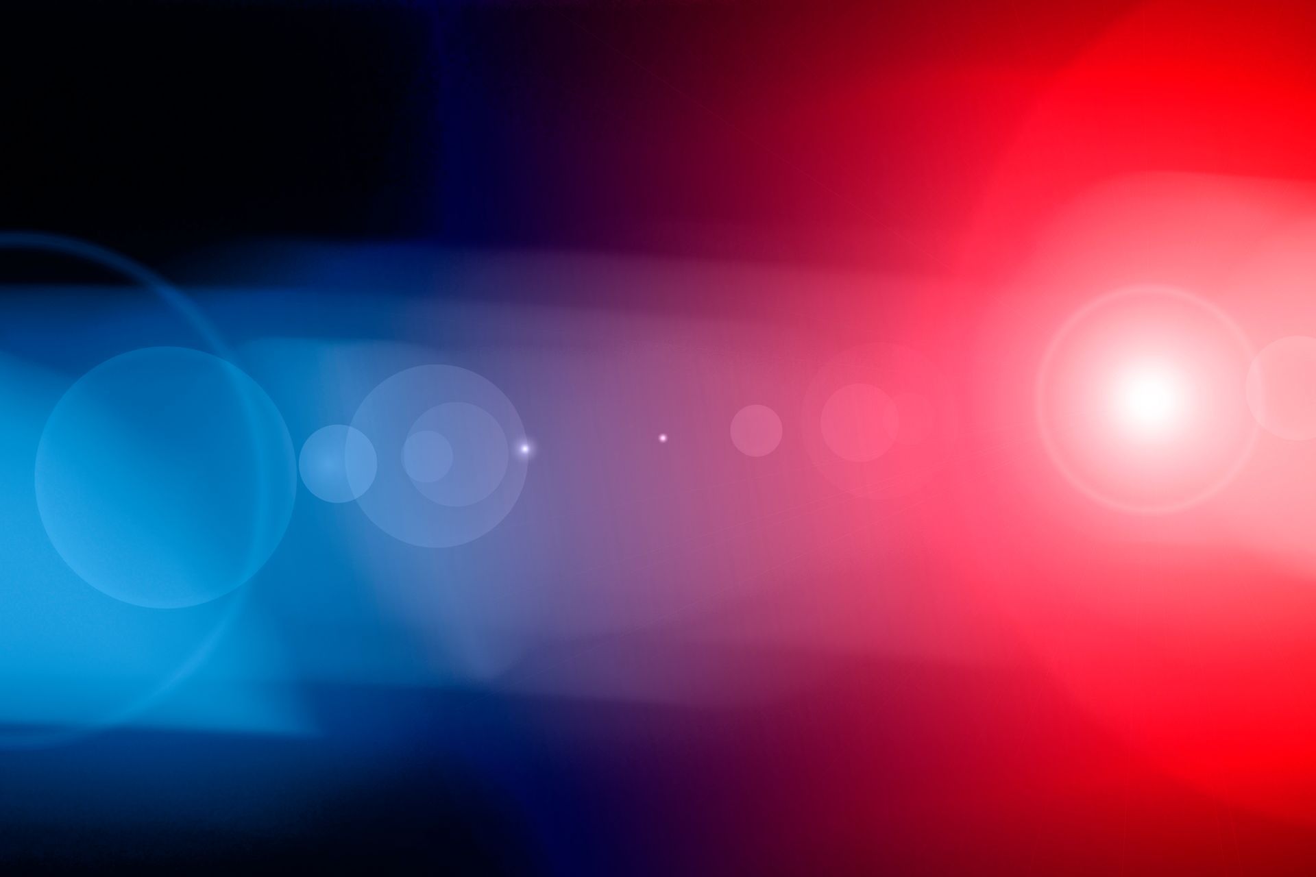 A red and blue light is shining on a black background.