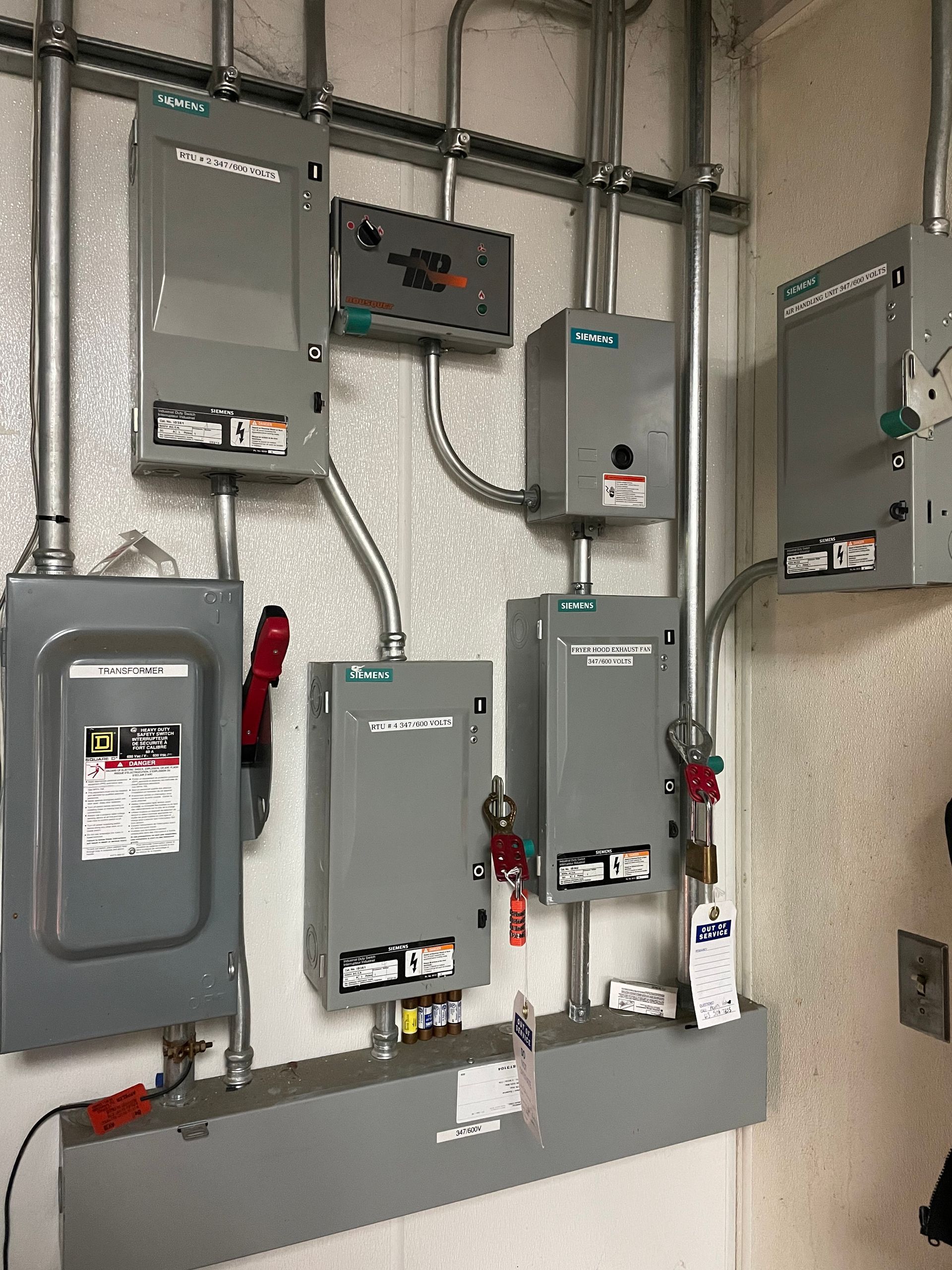 A bunch of electrical boxes are hanging on a wall.