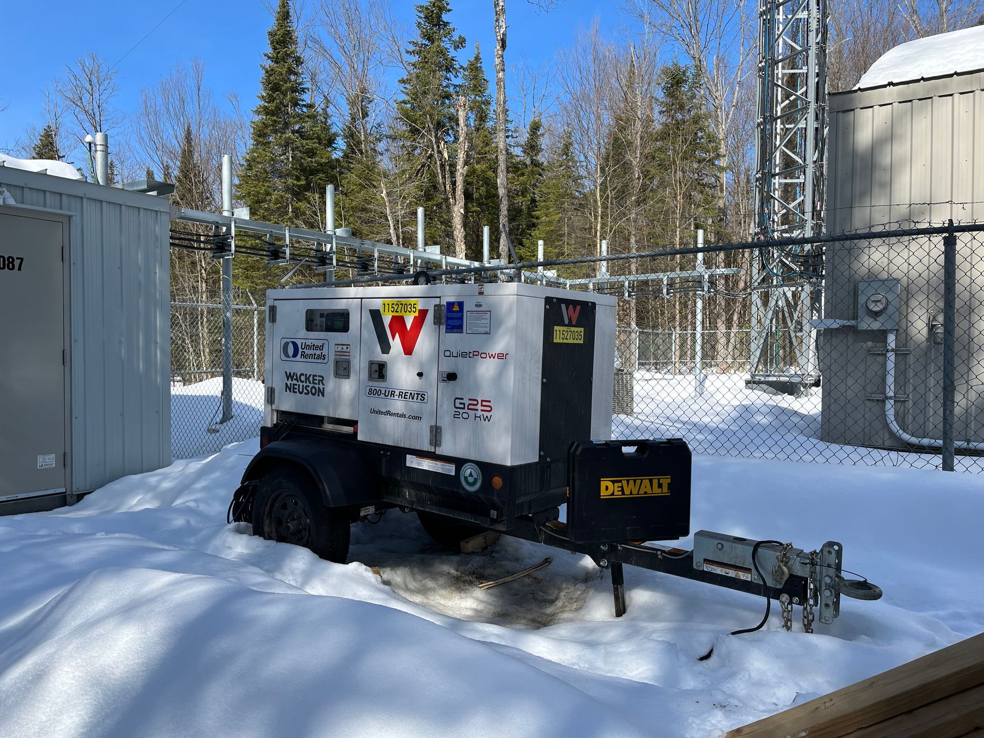 A generator is parked in the snow in front of a building.